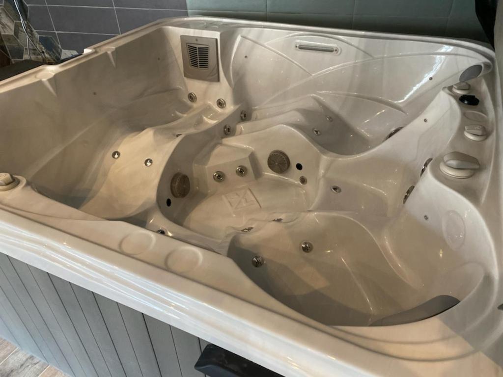 a large white bath tub sitting in a bathroom at Escapade Normande SPA in Yerville