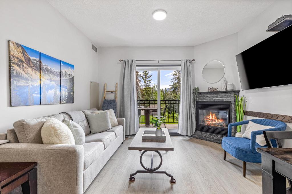 a living room with a couch and a fireplace at Outstanding Mountain Condo *WATERSLIDE* HOTTUB* hosted by Fenwick Vacation Rentals in Canmore