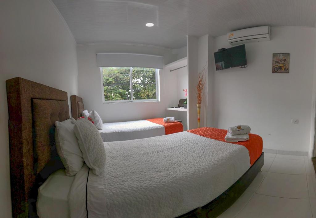 1 dormitorio con 2 camas y ventana en Hotel Royal Classy, en Villavicencio