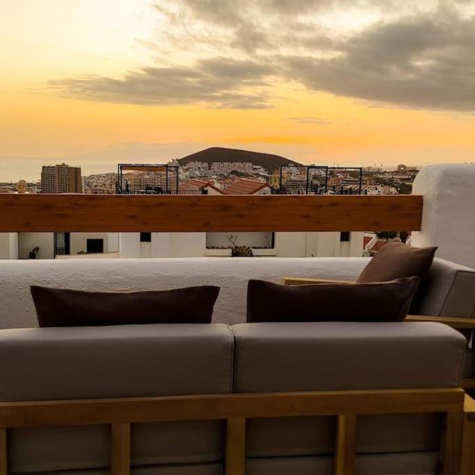 a couch on a balcony with a view of a city at Port Royale Los Cristianos Arona in Los Cristianos