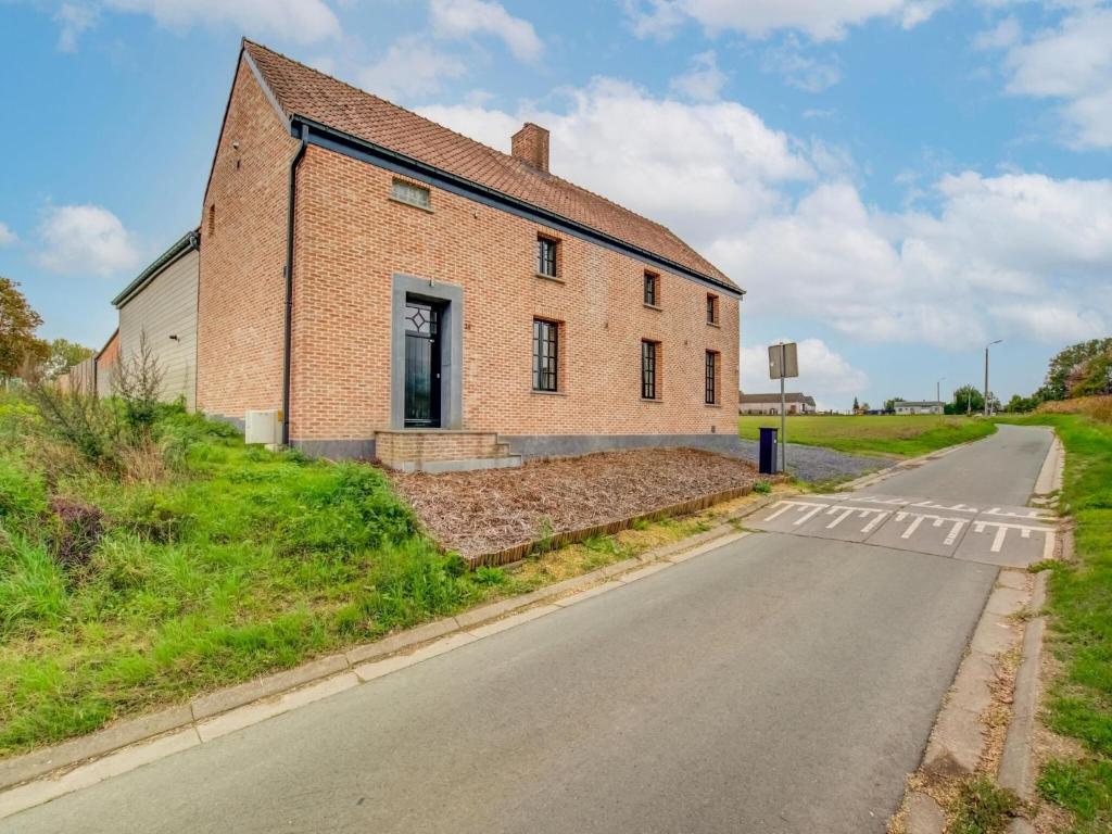 un viejo edificio de ladrillo al lado de una carretera en Lush holiday home in Vlaanderen with private pool, 