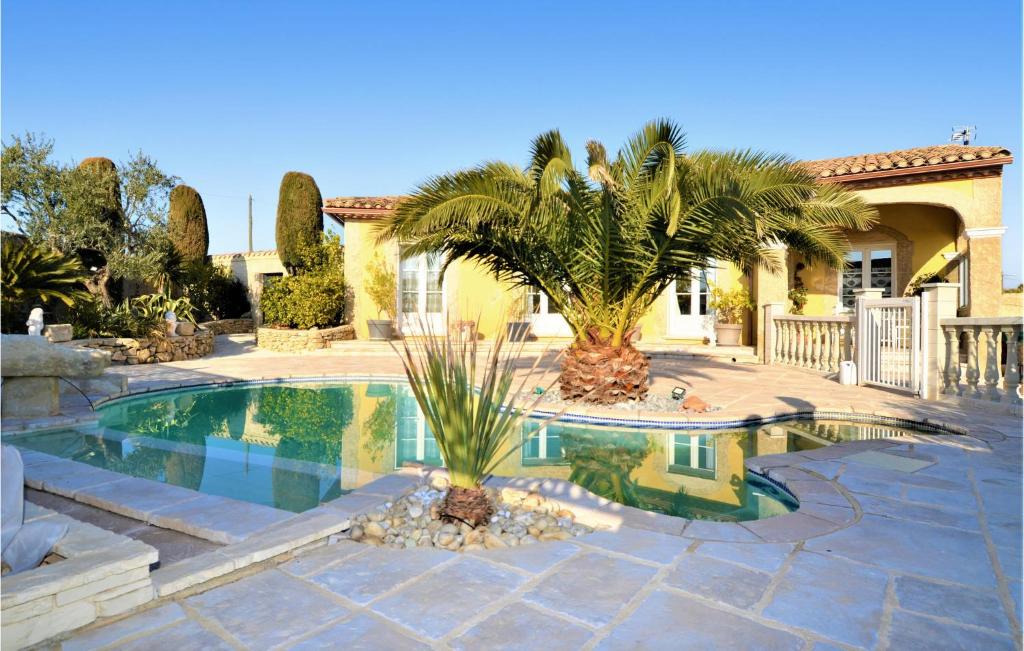 uma piscina com palmeiras num quintal em 3 Bedroom Nice Home In Jonquire Saint Vincen em Jonquières-et-Saint-Vincent