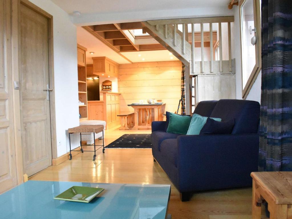salon z niebieską kanapą i stołem w obiekcie Duplex avec 4 chambres pour 10 à Méribel, proche pistes et commerces, parking inclus - FR-1-180-578 w mieście Les Allues