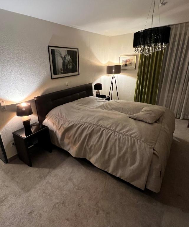 a bedroom with a large bed and a table with lamps at Hotel Exquisit in Minden