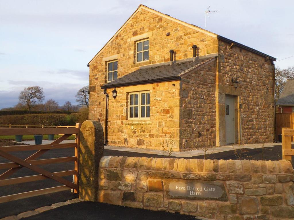 a stone building with a gate in front of it at Five Barred Gate Barn in Inglewhite