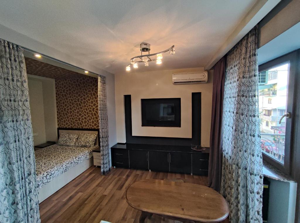 a bedroom with a bed and a tv on a wall at MY APARTMENT IN CENTRAL PARK in Batumi