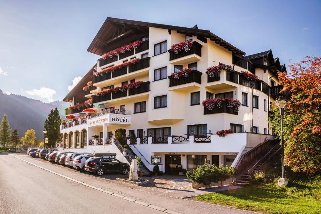 a large hotel with cars parked in front of it at Hotel Garni Alpenruh-Micheluzzi in Serfaus