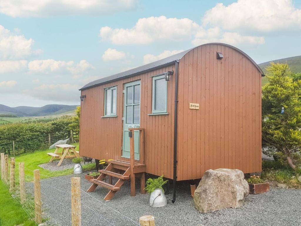 una casa pequeña con un banco y una mesa en Fell Foot - Ukc5294, en Bassenthwaite