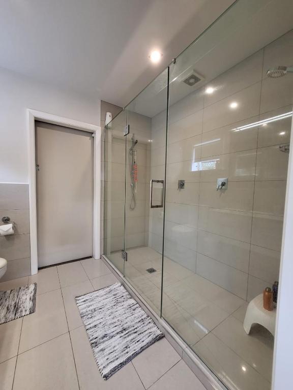 a bathroom with a shower and a glass shower stall at The perfect getaway for two in a large suite in Whanganui