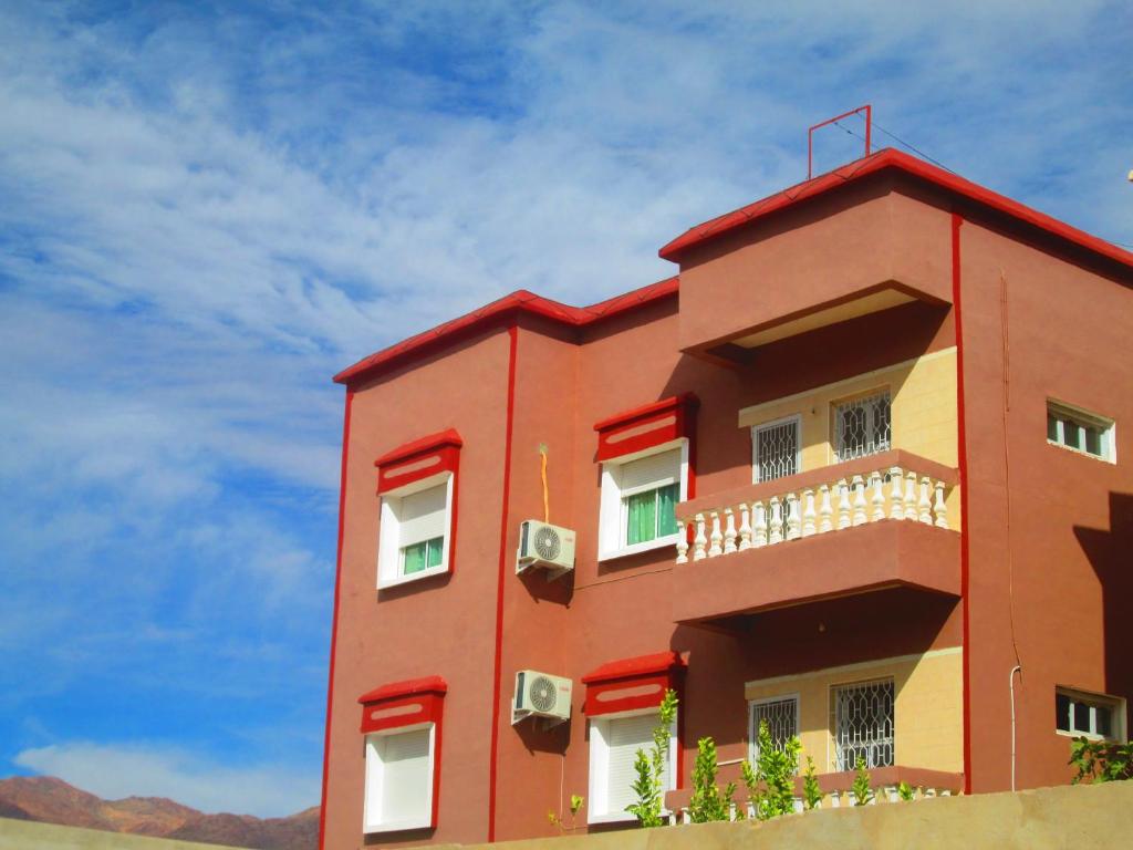 un edificio rojo con un cielo en el fondo en HoTEL AFOULKI, en Tafraoute