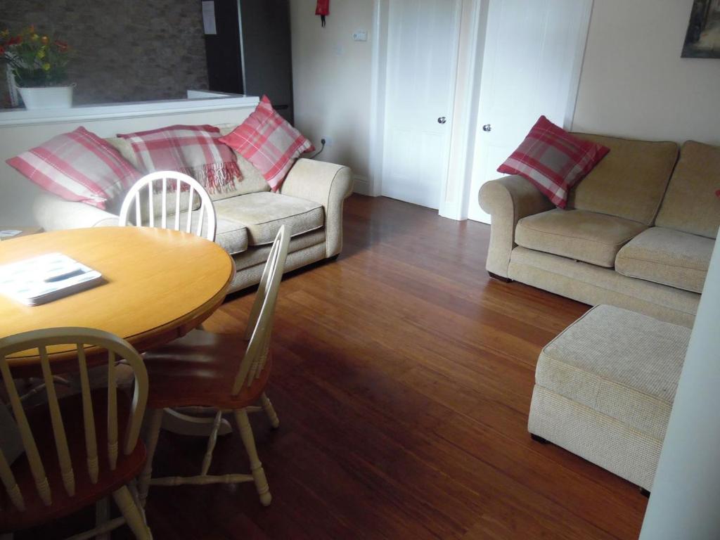 a living room with a table and a couch at Robins Nest in Broomhill