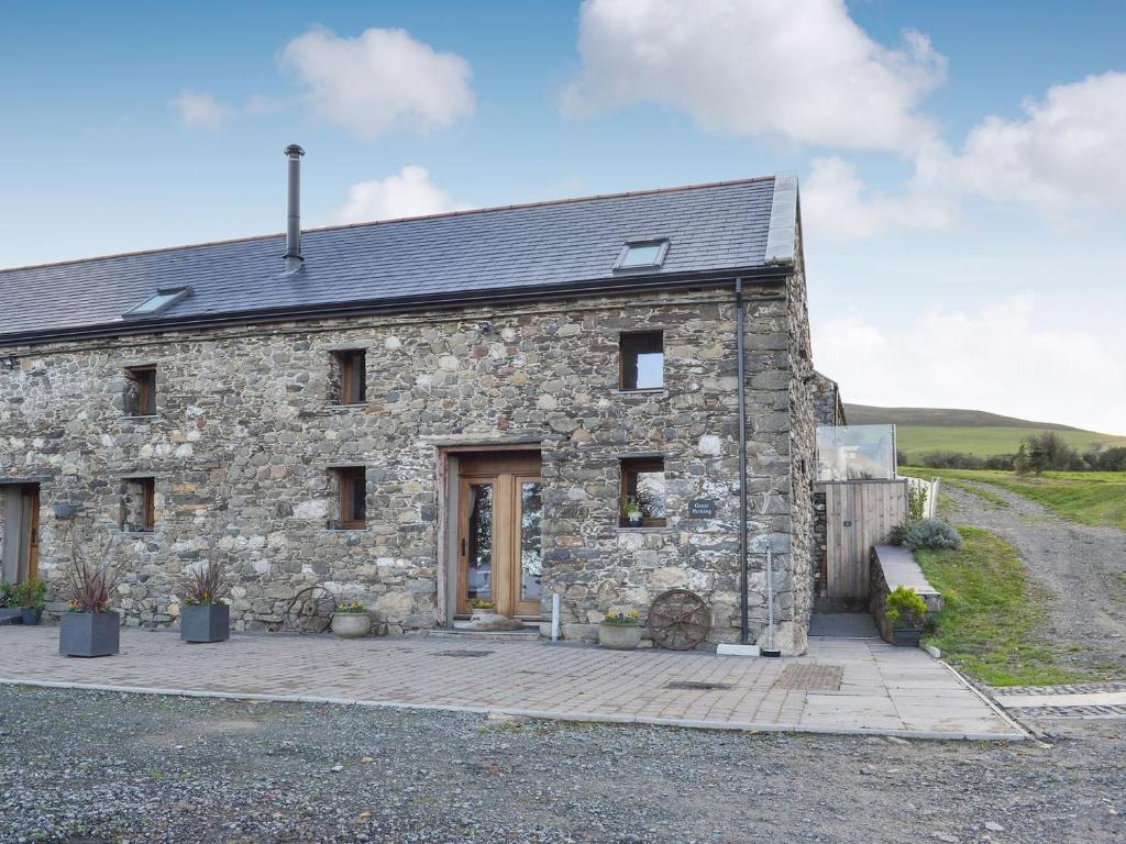 an old stone house with a driveway at 1 Barnagh Barn in Kirkmichael