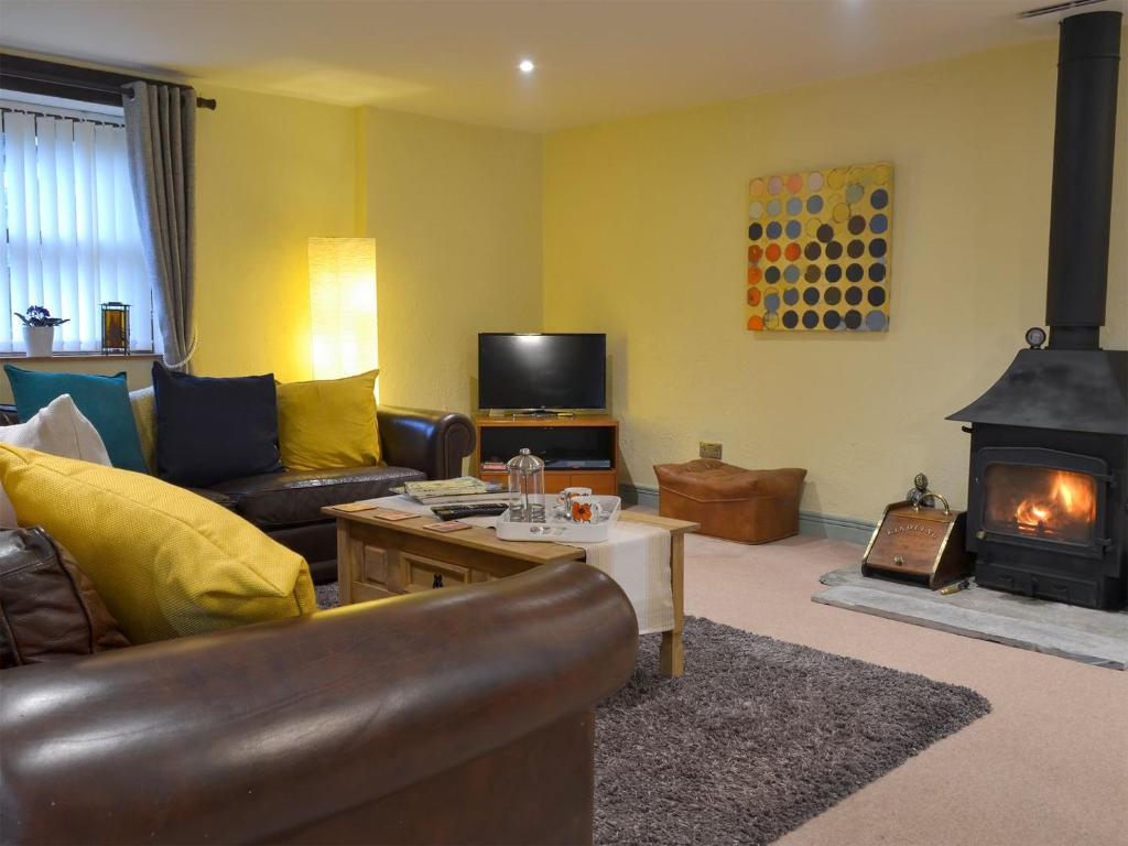 a living room with a couch and a fireplace at Church Barn in North Petherwin