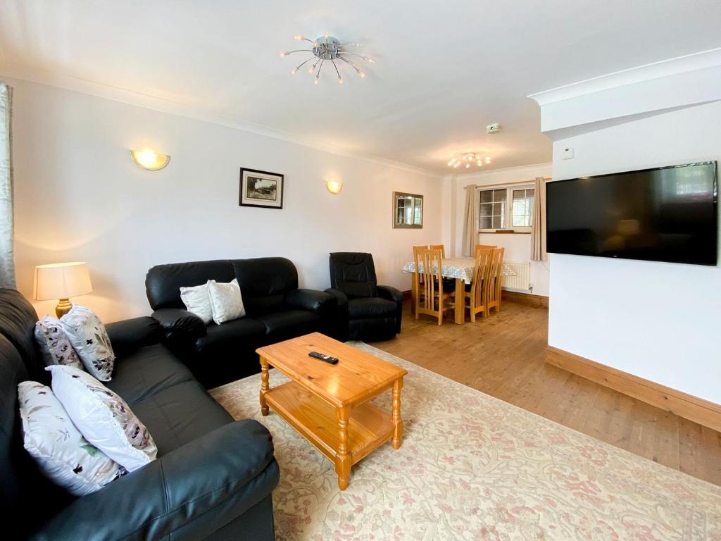 a living room with a couch and a tv and a table at Sweet Coppin in Ledbury