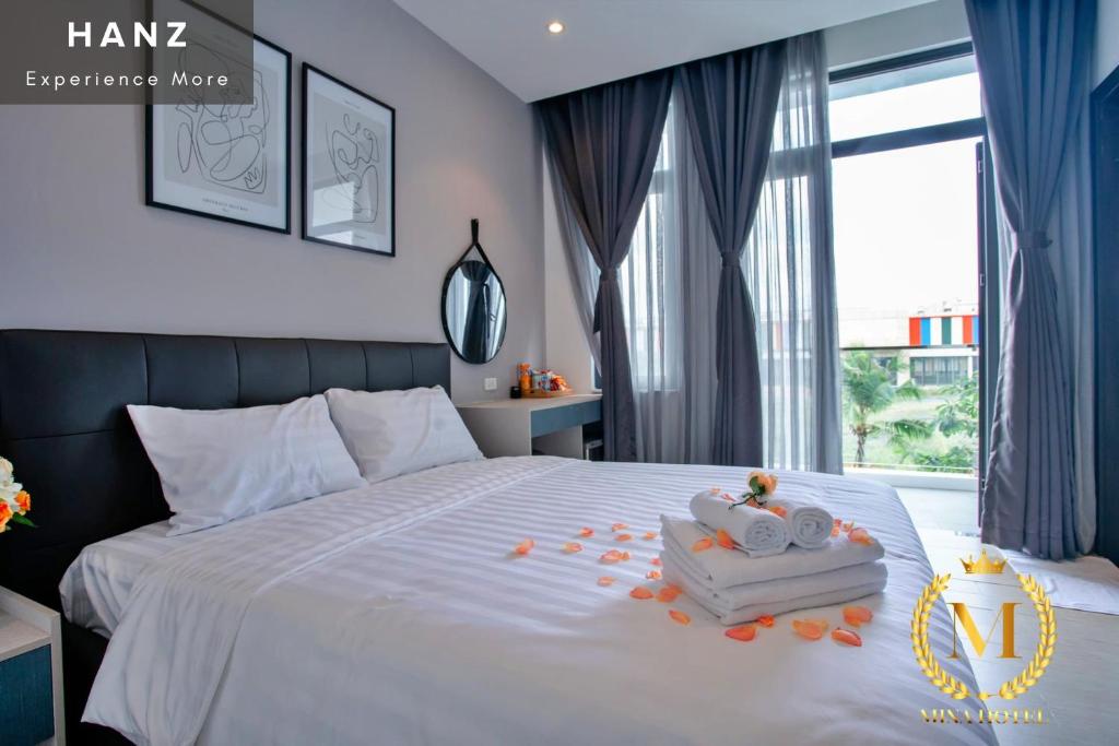 a bedroom with a white bed with toys on it at HANZ Mina Hotel in Ấp Long Khánh