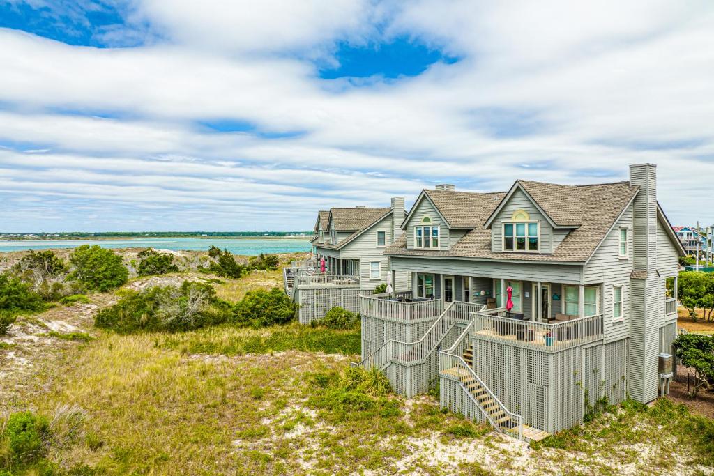 a house on the beach with the ocean in the background at Beach Blessings in Topsail Beach
