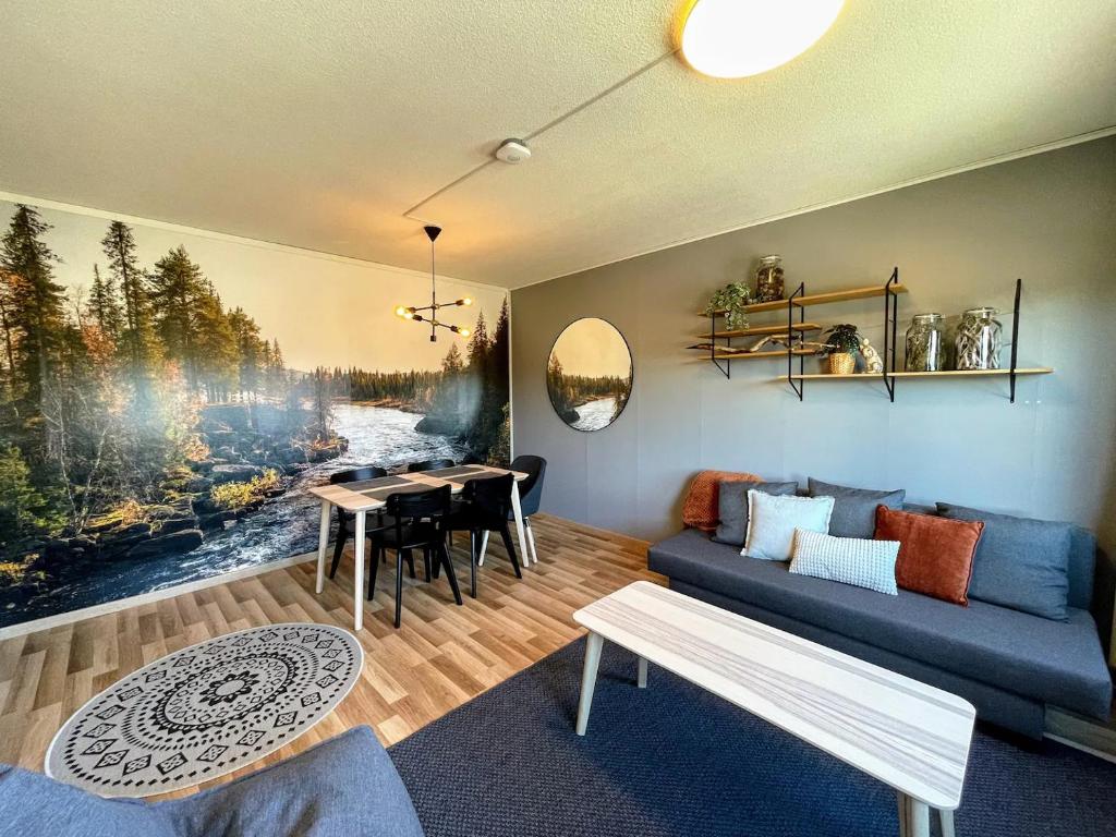 a living room with a blue couch and a table at Pine Sky in Ivalo