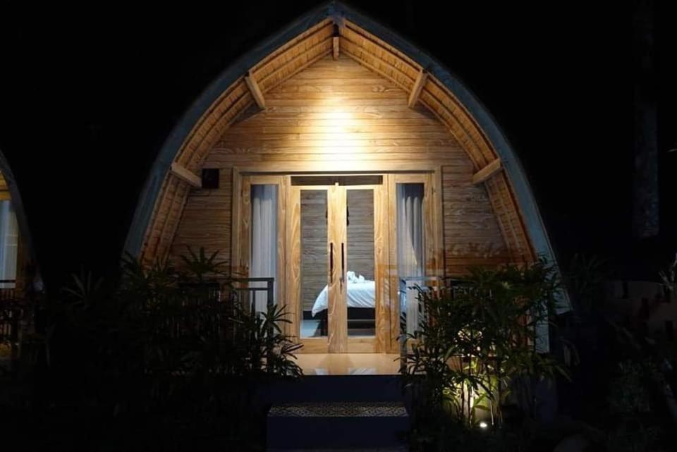 una pequeña casa de madera con ventana por la noche en Mulia Manise The Bahari Villas Bali en Pacung