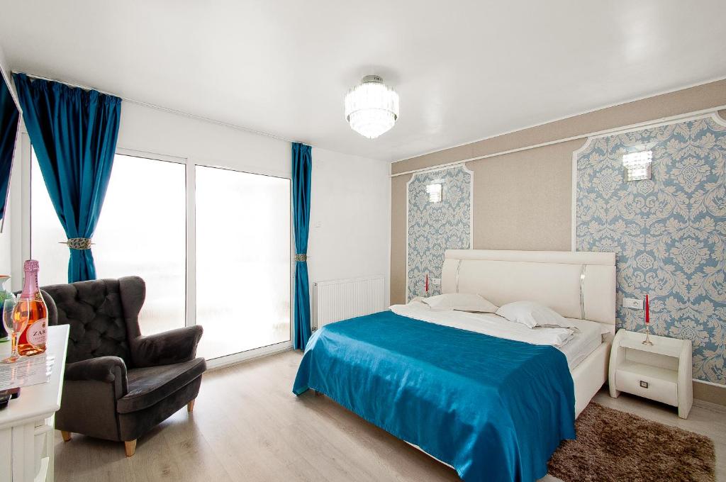 1 dormitorio con 1 cama y 1 silla en Panorama Dunarii, en Galaţi