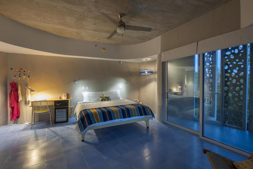 a bedroom with a large bed and a large window at El Blok in Vieques