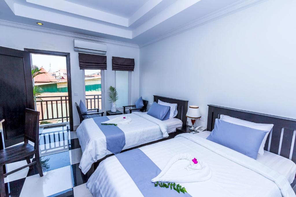 Postel nebo postele na pokoji v ubytování Rithy Rine Angkor Residence