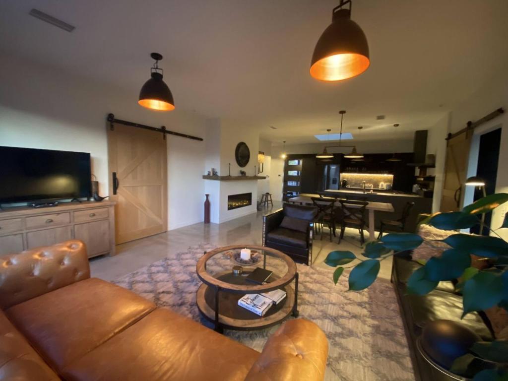 a living room with a couch and a table at Black Stilt Retreat, STUNNING luxury property in Twizel