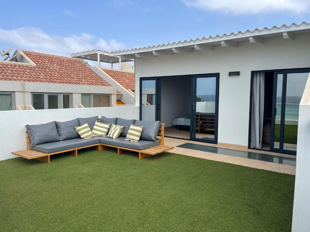a patio with a couch on a green lawn at New Rooftop Penthouse with Oceanview in Santa Maria