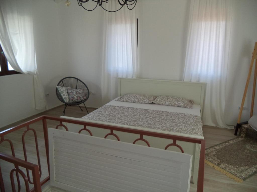 a bedroom with a bed and a chair at Chic sea front apartment with breathtaking Kotor Bay view in Donji Stoliv