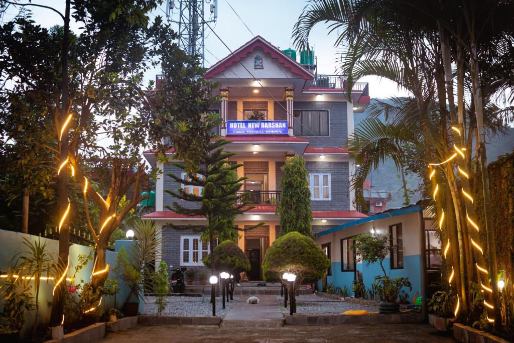 une grande maison avec des lumières devant elle dans l'établissement Hotel New Darshan, à Pokhara