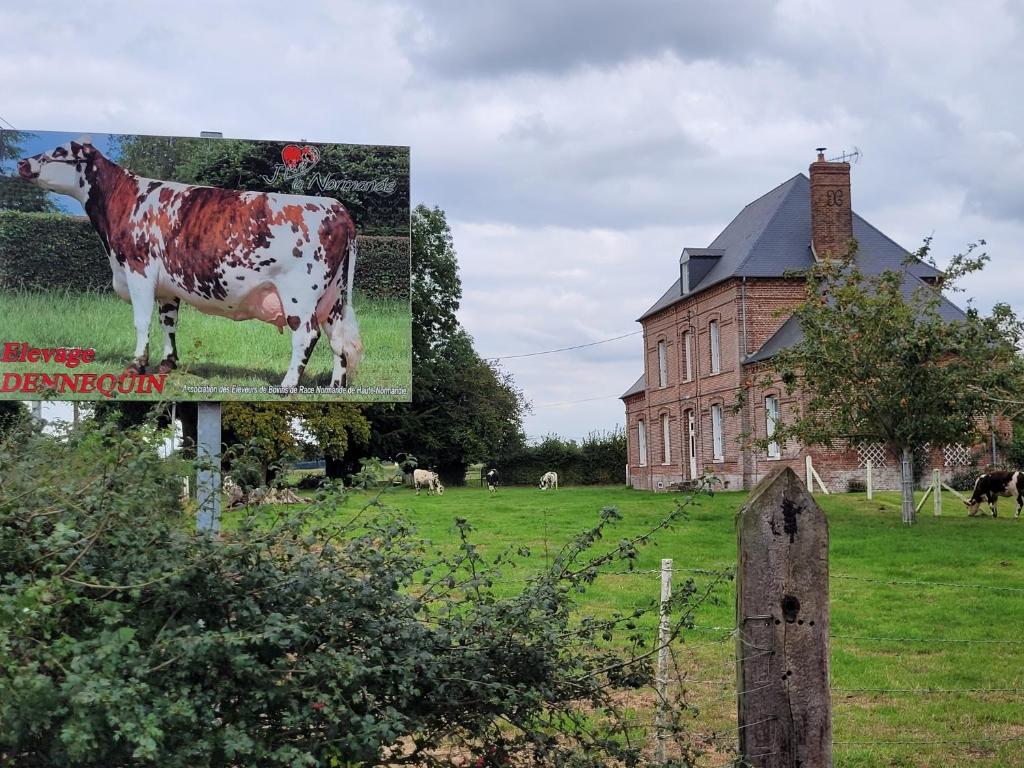 una foto de una vaca en un cartel en un campo en Chambre chez l'habitant 1 en Biville-la-Baignarde