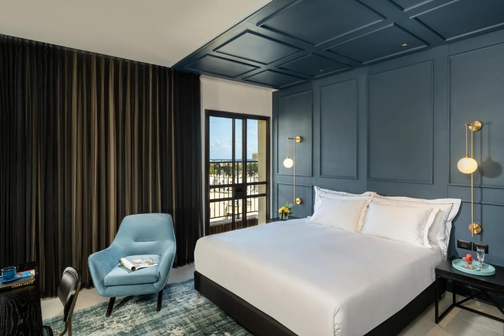 um quarto com uma cama e uma cadeira azul em Hotel Botanica- Limited Edition By Fattal em Haifa