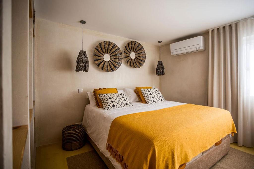 a bedroom with a bed and two mirrors on the wall at Sea'Ya Thoughtful Stays - Villas in Cascais