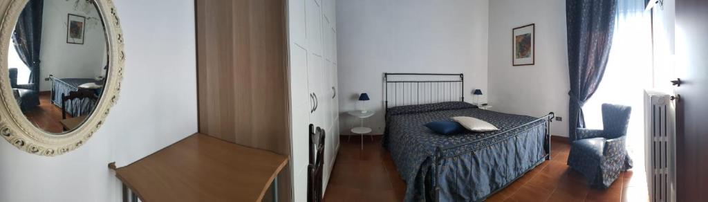 ein kleines Schlafzimmer mit einem Bett und einem Spiegel in der Unterkunft B&B L'Arcobaleno in Cherasco