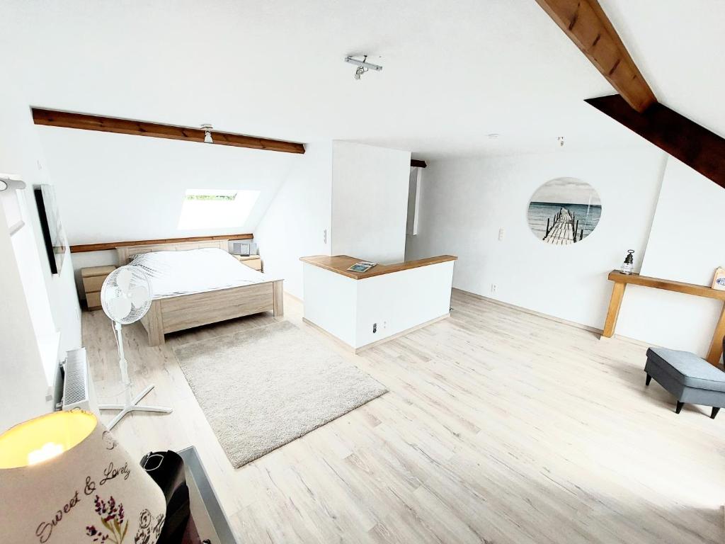 Dieses weiße Zimmer verfügt über ein Bett und einen Schreibtisch. in der Unterkunft Studio Autonome Mont Saint Guibert in Mont-Saint-Guibert
