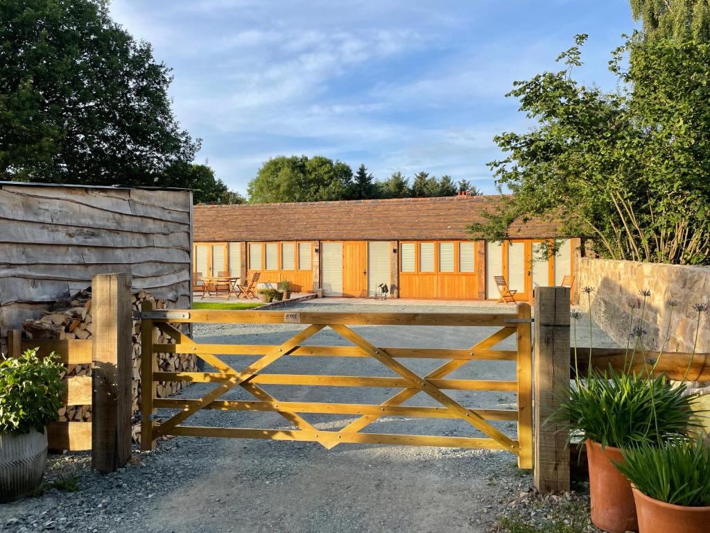 a wooden gate in front of a building at Beautiful countryside Byre conversion in Shrewsbury