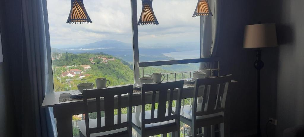 a room with a large window with a table and chairs at Epie's Pad in Tagaytay