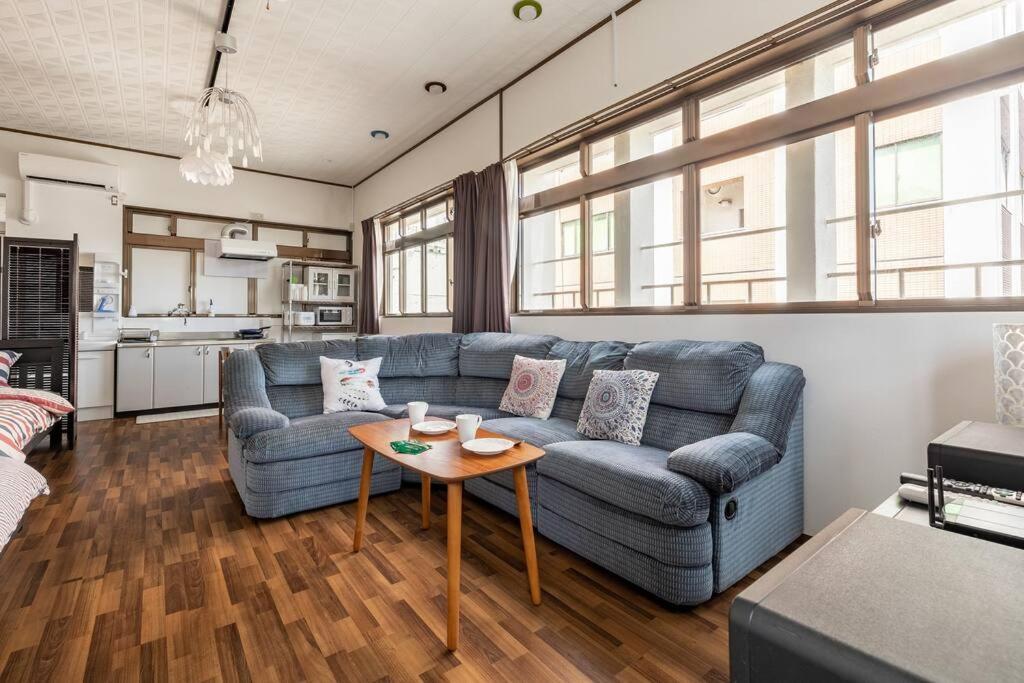 sala de estar con sofá azul y mesa en 2フロア貸切最大15名 国際通り徒歩1分 駐車場1台無料 Paradise inn 安里 en Naha