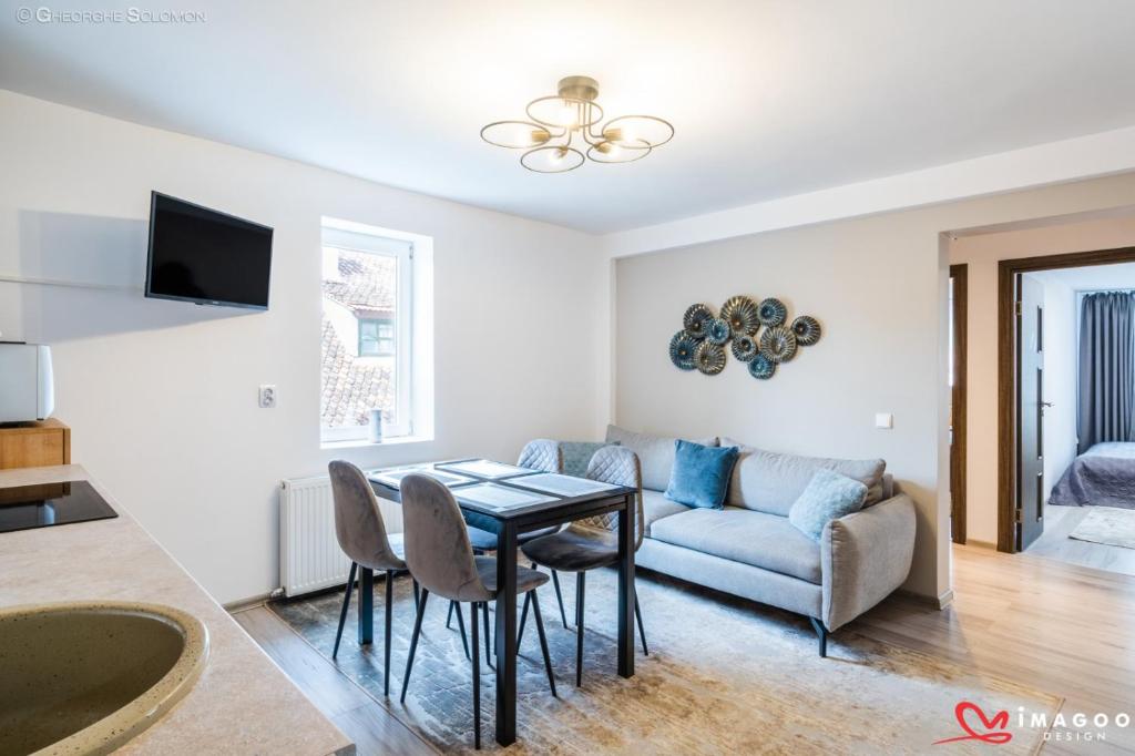 a living room with a table and a couch at Long street suites in Braşov