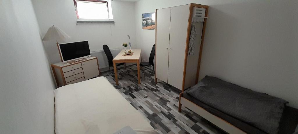 een kleine kamer met een slaapkamer met een bureau en een bed bij Gästezimmer Salzgitter II in Wolfenbüttel in Wolfenbüttel