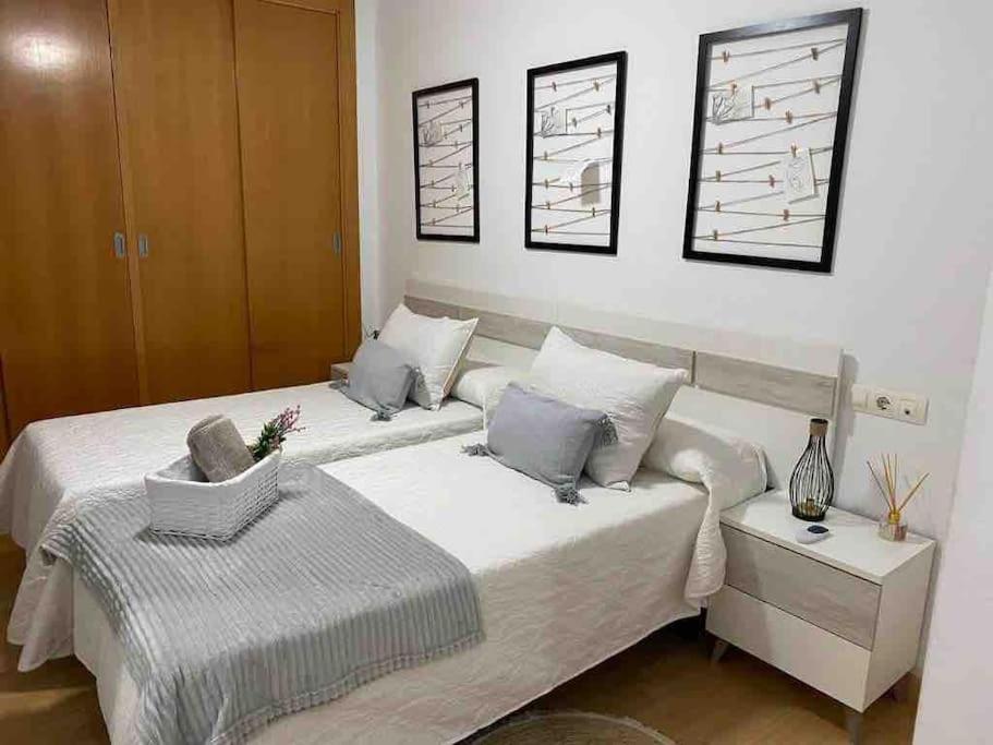 1 dormitorio con 2 camas con sábanas blancas en Precioso apartamento en zona de playa, en Almería