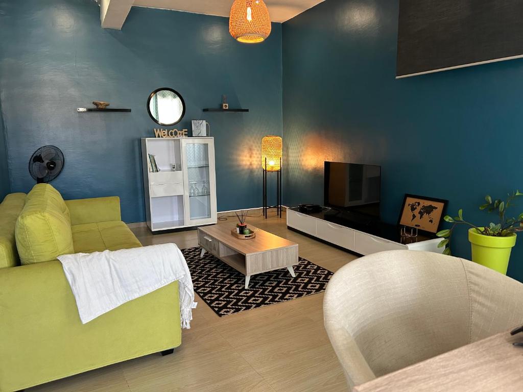 Mamoudzou的住宿－Charmant appartement avec terrasse, vue sur lagon，客厅配有绿色沙发和电视