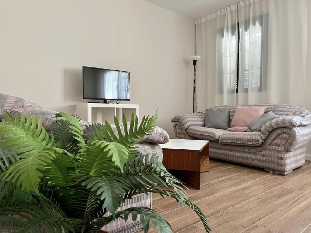 a living room with a couch and a table at Apartamentos El Piquillo en Cadalso de los Vidrios in Cadalso de los Vidrios