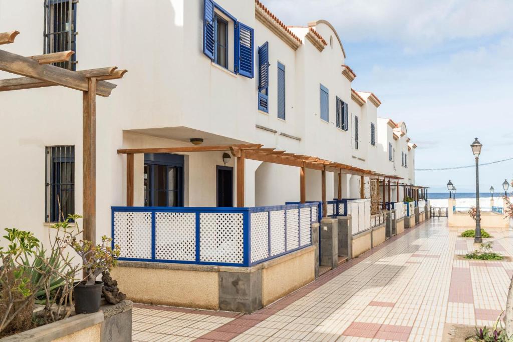 eine Reihe von Häusern mit blauen Rollläden auf einer Straße in der Unterkunft Vivienda Agaete Paradise in Puerto de las Nieves