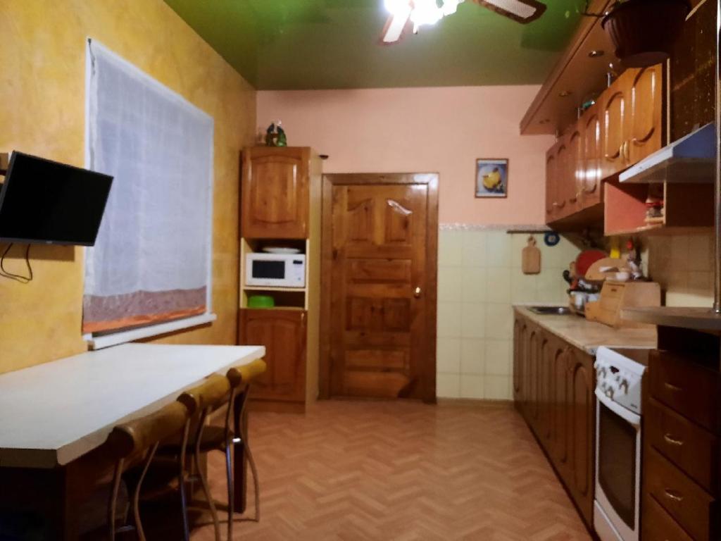 a kitchen with wooden cabinets and a white counter top at Гостевой коттедж 