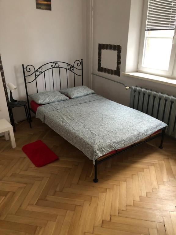 a bedroom with two beds and a wooden floor at Pokój 12C in Krakow