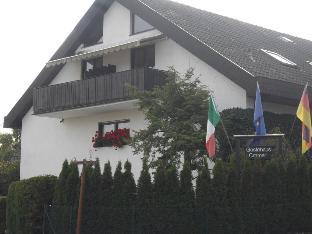 a white house with two flags in front of it at Gästehaus Cramer in Bad Kissingen