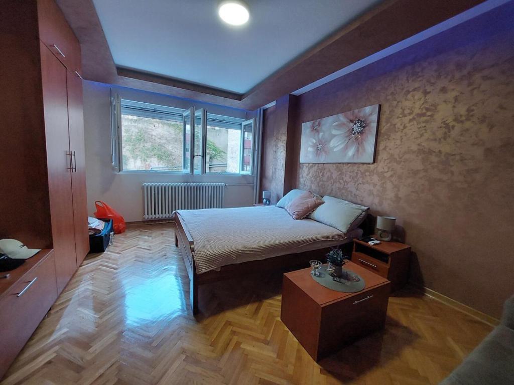 ein kleines Schlafzimmer mit einem Bett und einem Tisch in der Unterkunft Cuca Apartments in Belgrad