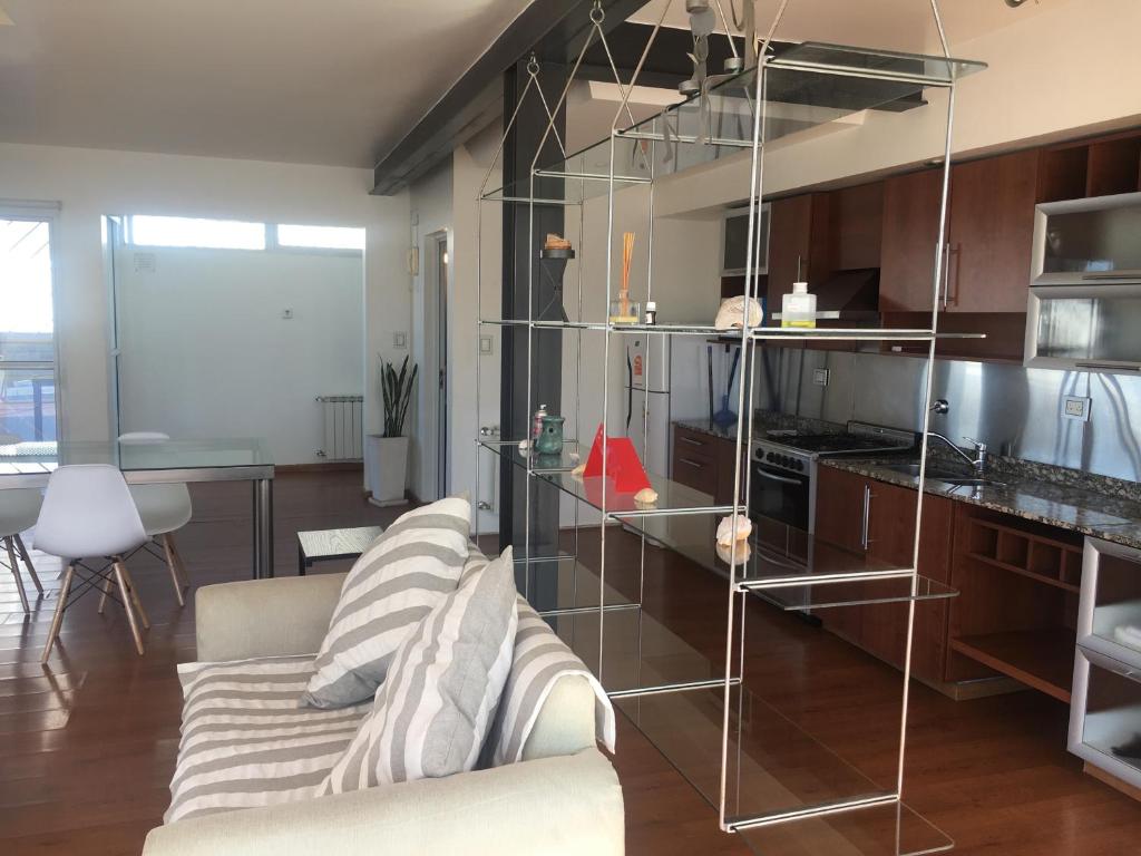 sala de estar con sofá y cocina en Rio Negro Loft en Viedma