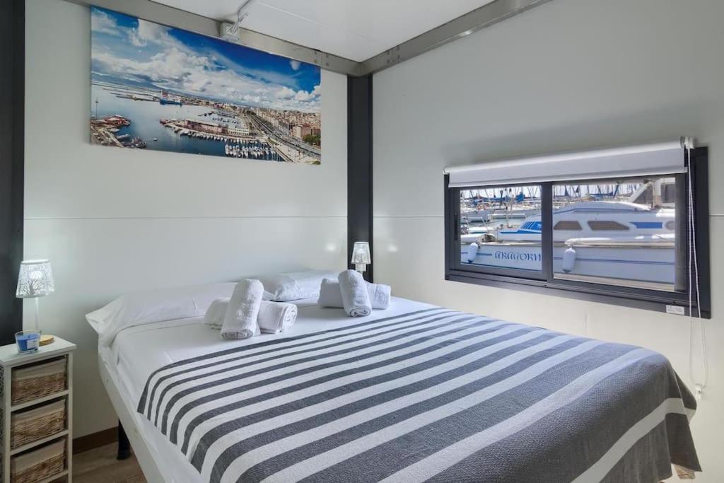 1 dormitorio con 1 cama y ventana grande en Houseboat Sardinia Suite, en Cagliari