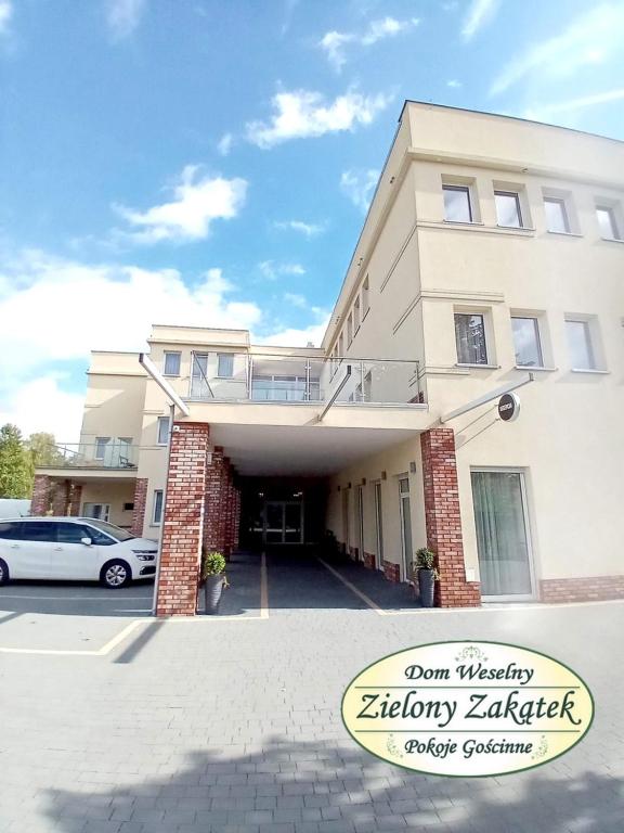 um carro branco estacionado em frente a um edifício em Dom Weselny Zielony Zakątek em Jarocin